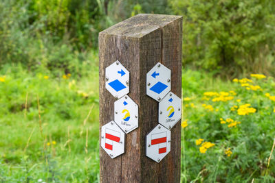 Close-up of information sign on wooden post