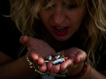 Woman holding medicine while sitting on table outdoors