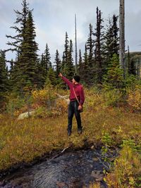 Young man standing at forest during autumn