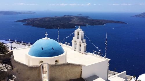 High angle view of chruch with blue dome against blue sea in greece