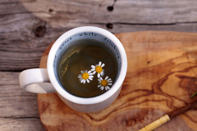 Close-up of white daisies in herbal tea on table