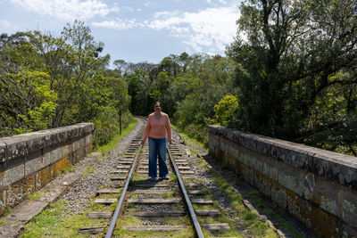 Rear view of man walking on railroad track