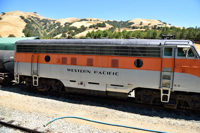 Train on railroad track by mountains against sky