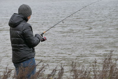 Rear view of man standing in water