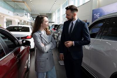 Salesman talking to customer in car showroom