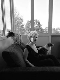Woman with dog sitting at window