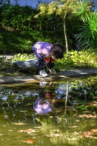 Reflection of woman on water in lake