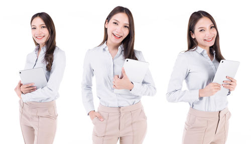 Portrait of a smiling young woman standing against white background