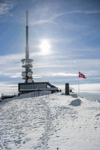 Lifeguard hut on snow covered landscape against sky