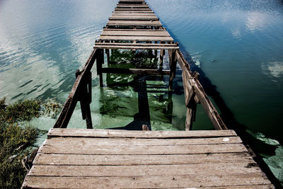High angle view of man standing on pier at lake