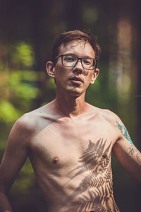 Portrait of shirtless man standing outdoors