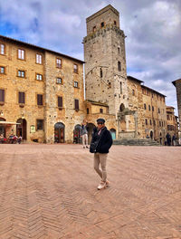 Full length of man walking in historic building against sky