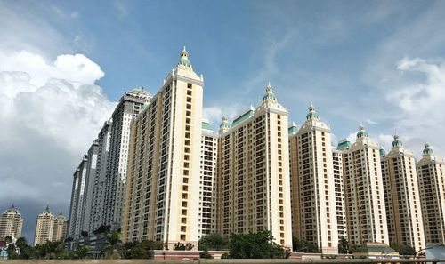 Low angle view of buildings against cloudy sky