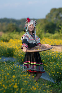 Woman with umbrella standing on field