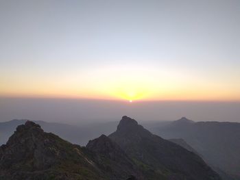 Scenic view of mountains against clear sky during sunset