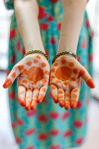 Midsection of woman with henna tattoo on hand