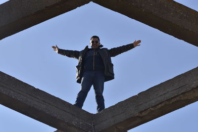 Low angle view of man standing against sky