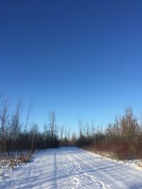 Scenic view of snow field against clear blue sky