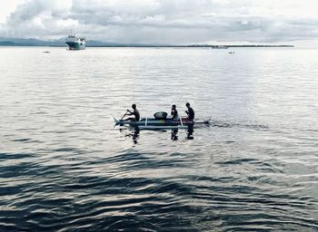 People in boat on sea against sky