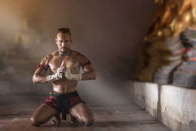 Portrait of fighter kneeling in temple