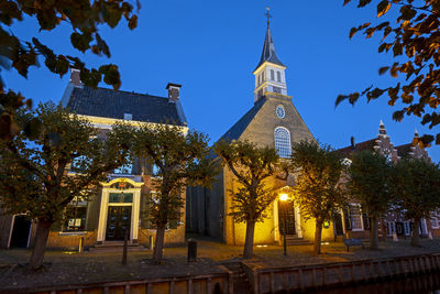 Low angle view of trees and buildings against sky