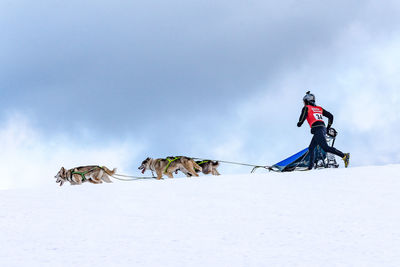 Man on snow covered mountain against sky