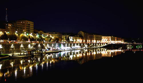 Illuminated town against clear sky at night