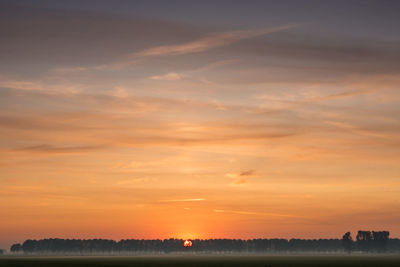 Scenic view of silhouette field against sky during sunset