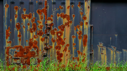 Full frame shot of rusty metal on field against wall