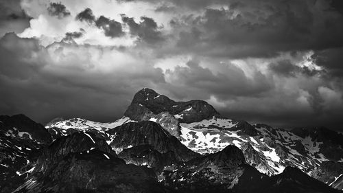 Snow covered mountains against cloudy sky