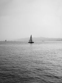 Sailboat sailing on sea against clear sky