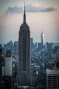 Modern buildings in city against sky during sunset