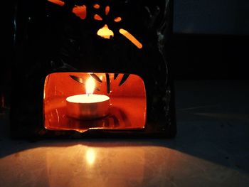 Close-up of lit candle in dark room