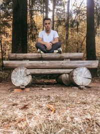 Portrait of young man sitting on field