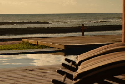 Close-up of wooden pier over sea against sky