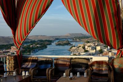 Panoramic view of river and buildings in city through colorful curtain