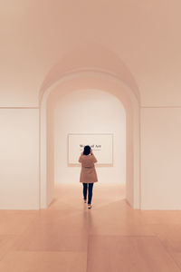 Rear view of woman standing in front of museum