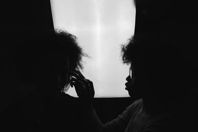 Close-up of women against window in darkroom