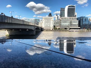 Bridge over river in city against sky