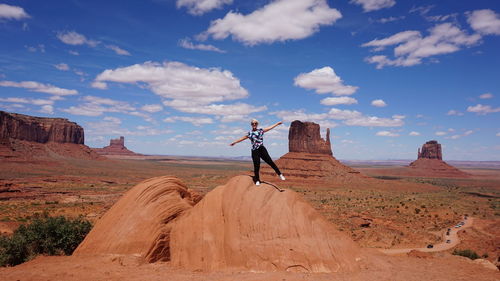 Woman standing on landscape against sky