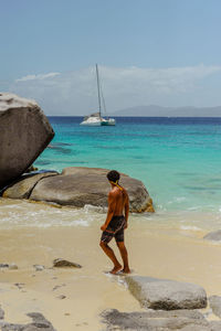 Rear view of woman standing at beach