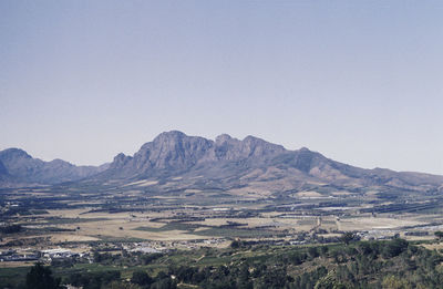 Scenic view of landscape and mountains against clear sky