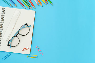 High angle view of pen on table against blue background