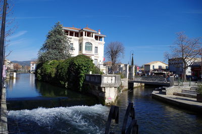 Boats moored in canal along buildings