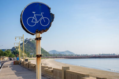 Close-up of bicycle sign against clear blue sky