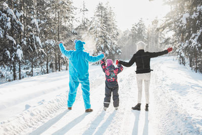 Full length of family on snow covered field
