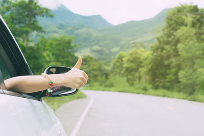 Midsection of woman with umbrella on road