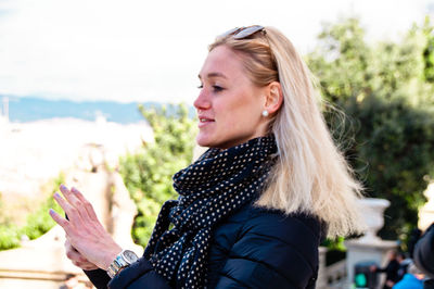 Side view of young woman looking away while standing outdoors