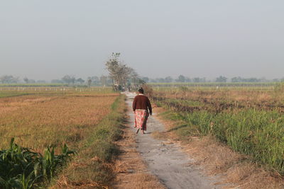 Barefoot woman walking on a country road