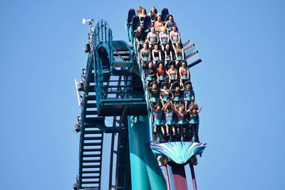 Low angle view of people against blue sky